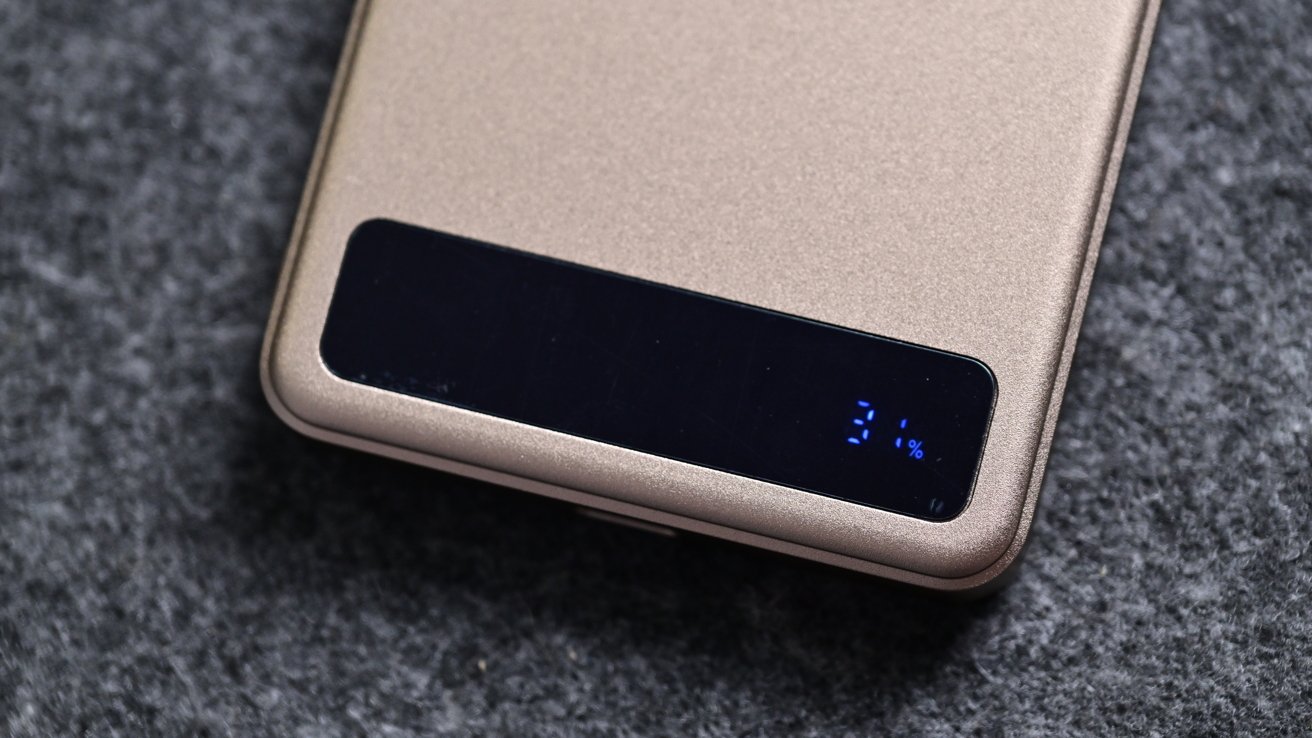 Gold device with a black digital screen displaying '31%' on a gray textured surface.