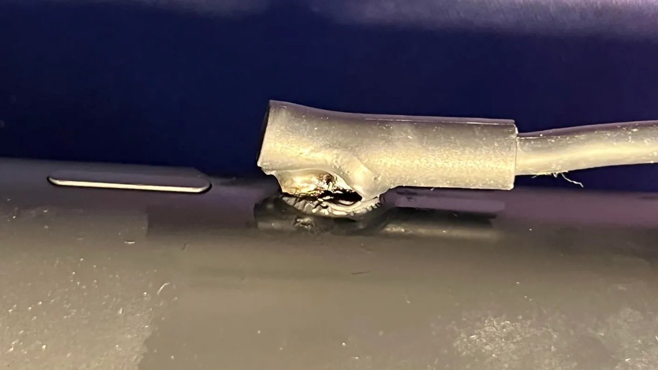 Melted and burned cable on a metallic surface, showing visible damage and distortion.