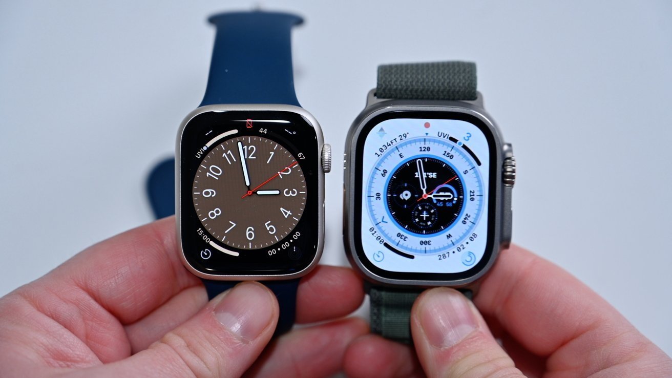 Two smartwatches held side by side, one with a brown clock face, the other with a technical dial and white background.