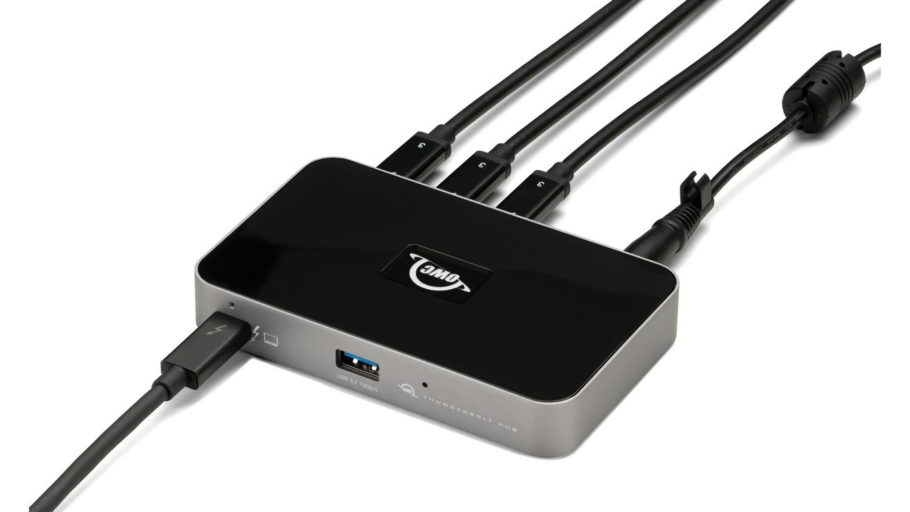Rectangular black and gray electronic hub with multiple connected cables, including USB and Thunderbolt ports.