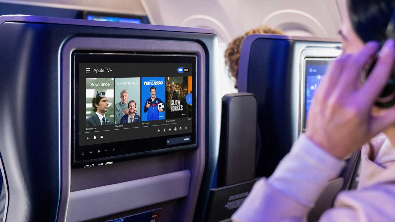 Airplane seatback screen displays Apple TV+ shows like Severance and Ted Lasso. Passenger wearing headphones looks on.