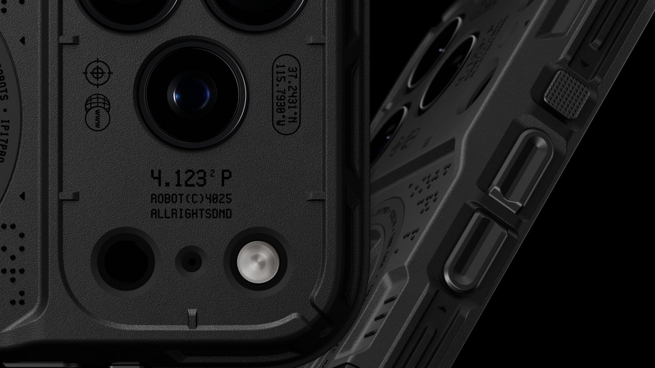 Close-up of a rugged black device with various buttons, ports, and circular lens components, featuring a textured surface and etched labels or markings.