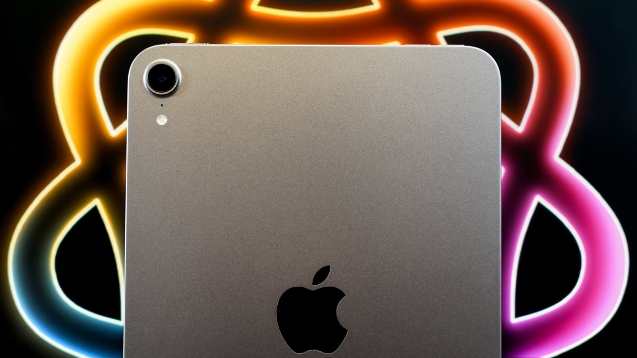 Close-up of a metallic device with a camera and Apple logo, against a colorful blurred background with orange and pink accents.