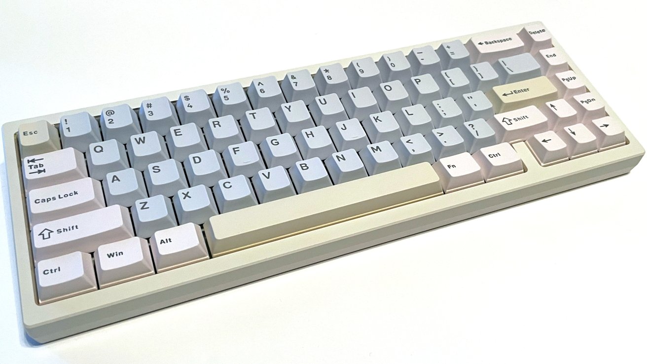 A compact mechanical keyboard with white and pastel-colored keycaps arranged in a tenkeyless layout, displayed on a white surface.