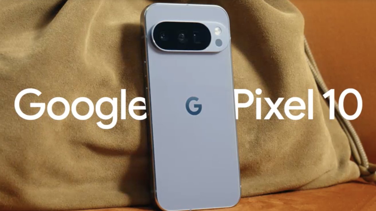 A Google Pixel 10 phone with a gray back and an oval camera module, resting on a tan fabric surface.