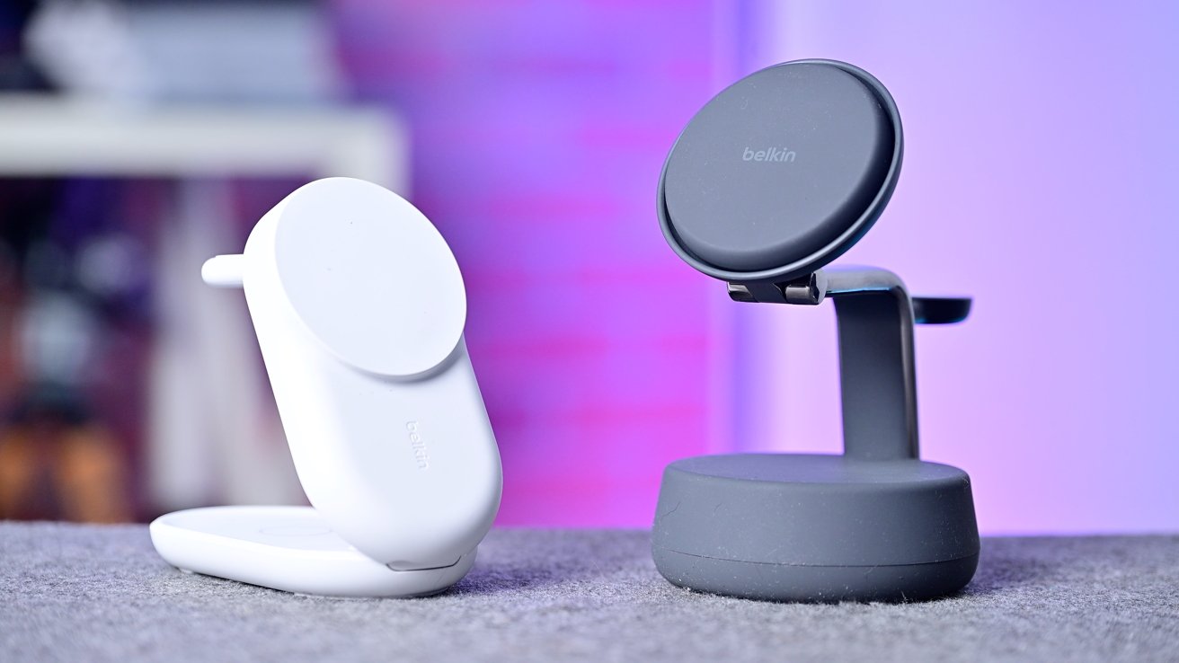 Two wireless chargers are displayed on a table, one black and one white, with a blurred purple and pink background.