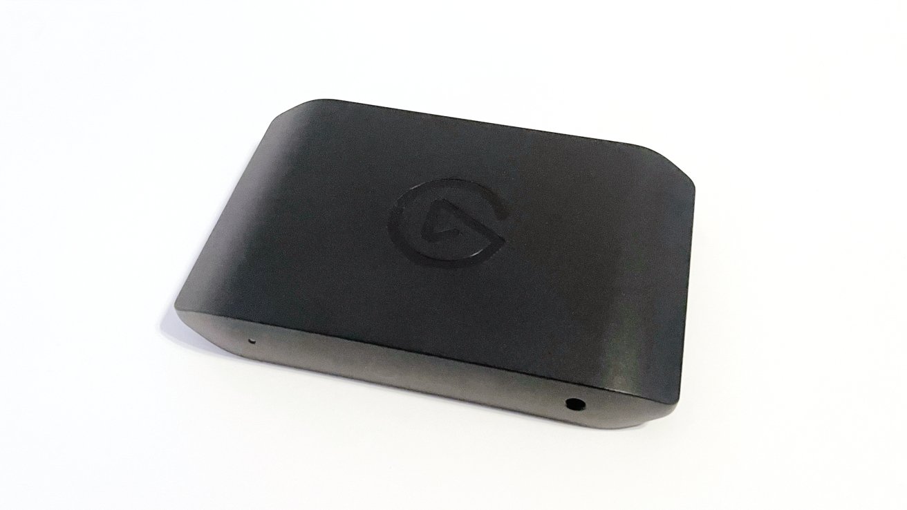 A black rectangular device with rounded edges, featuring a subtle logo engraved on the top surface, placed on a white background.