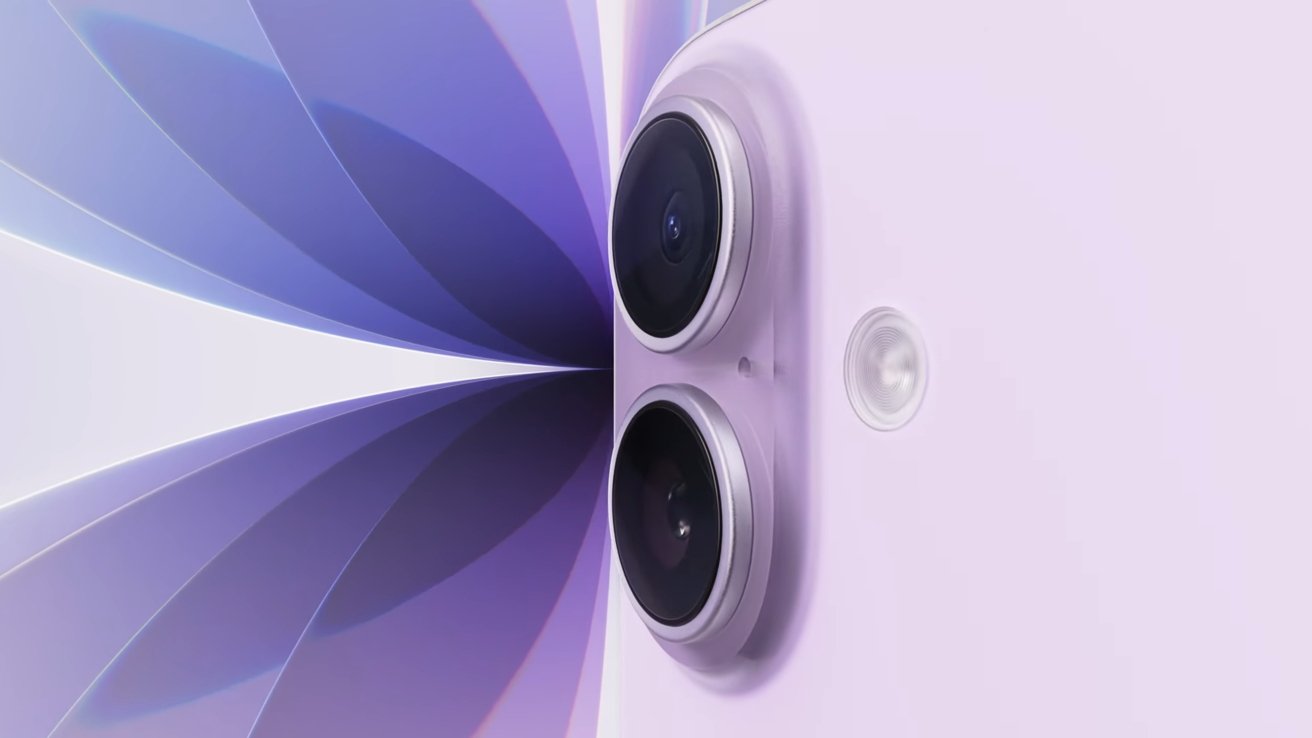 Close-up of two black camera lenses on a purple surface with a purple abstract design in the background.