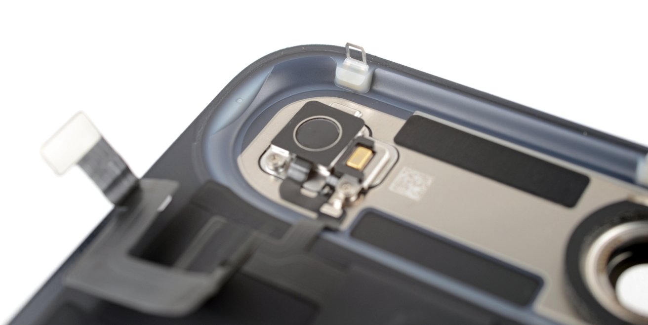 Close-up of a smartphone's camera assembly showing lenses, metallic components, and connection points inside the device.