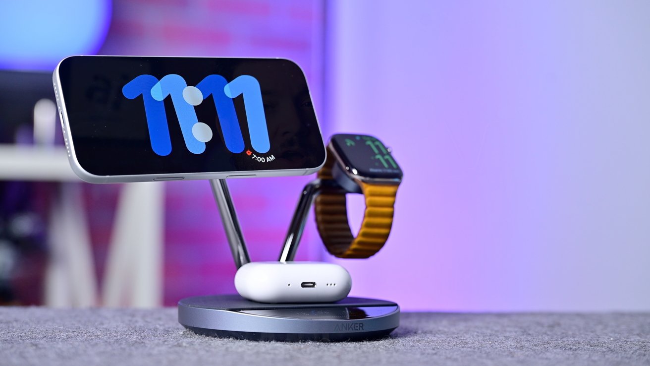 Smartphone displaying 11:11 and Apple Watch on a sleek dual charging stand with AirPods, against a blurred purple and pink background.