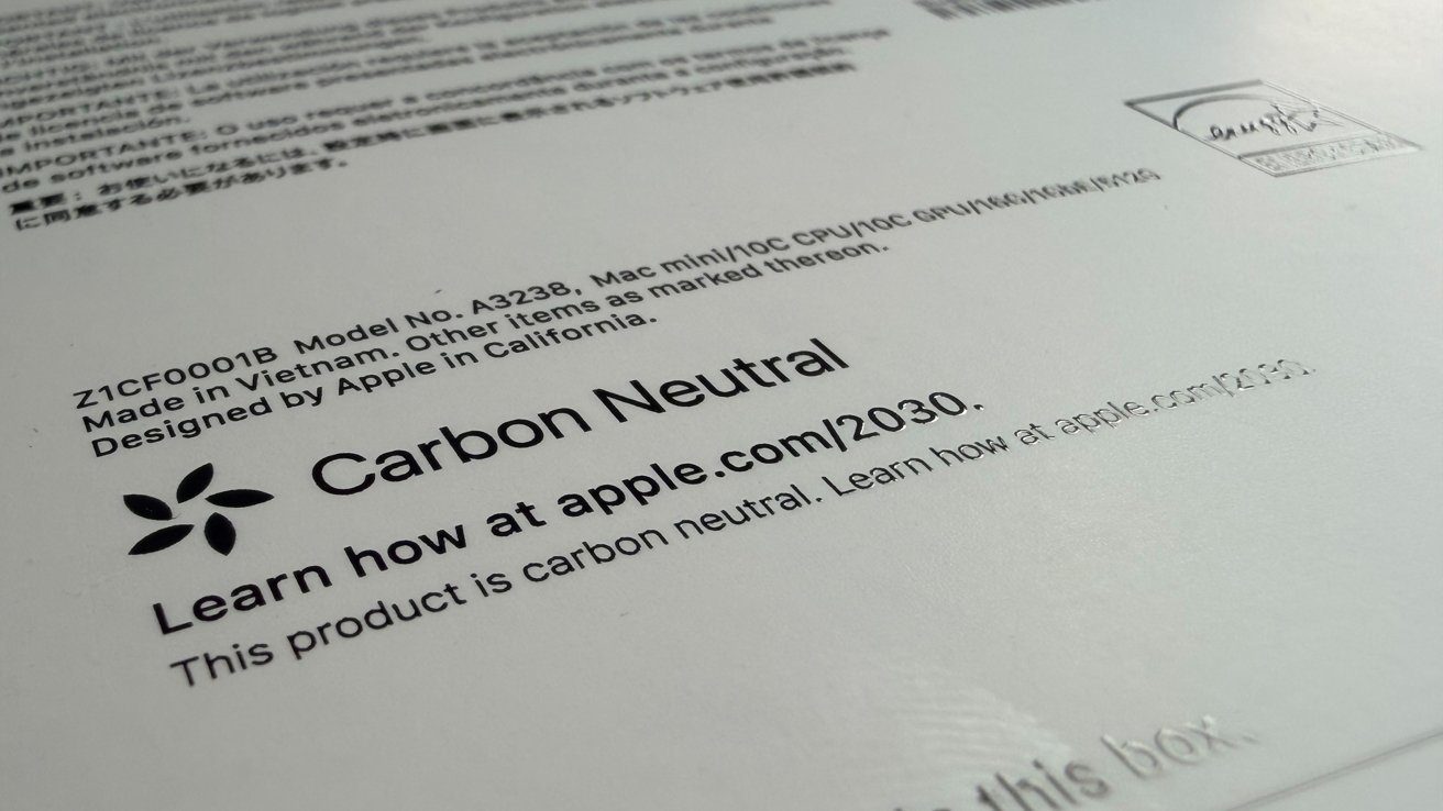 Text on a box indicating a product is carbon neutral, designed by Apple, made in Vietnam. Website link for more information.