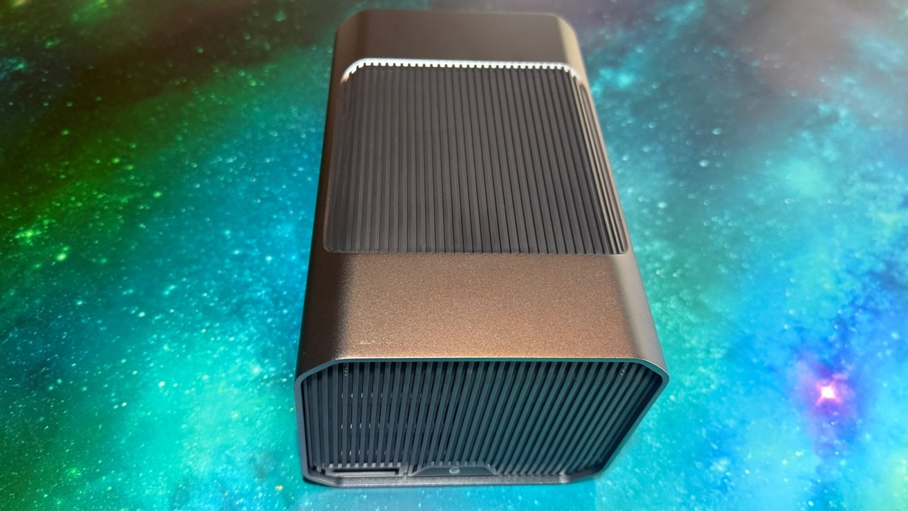 A black rectangular electronic device with a ribbed design against a vibrant, multicolored starry background.