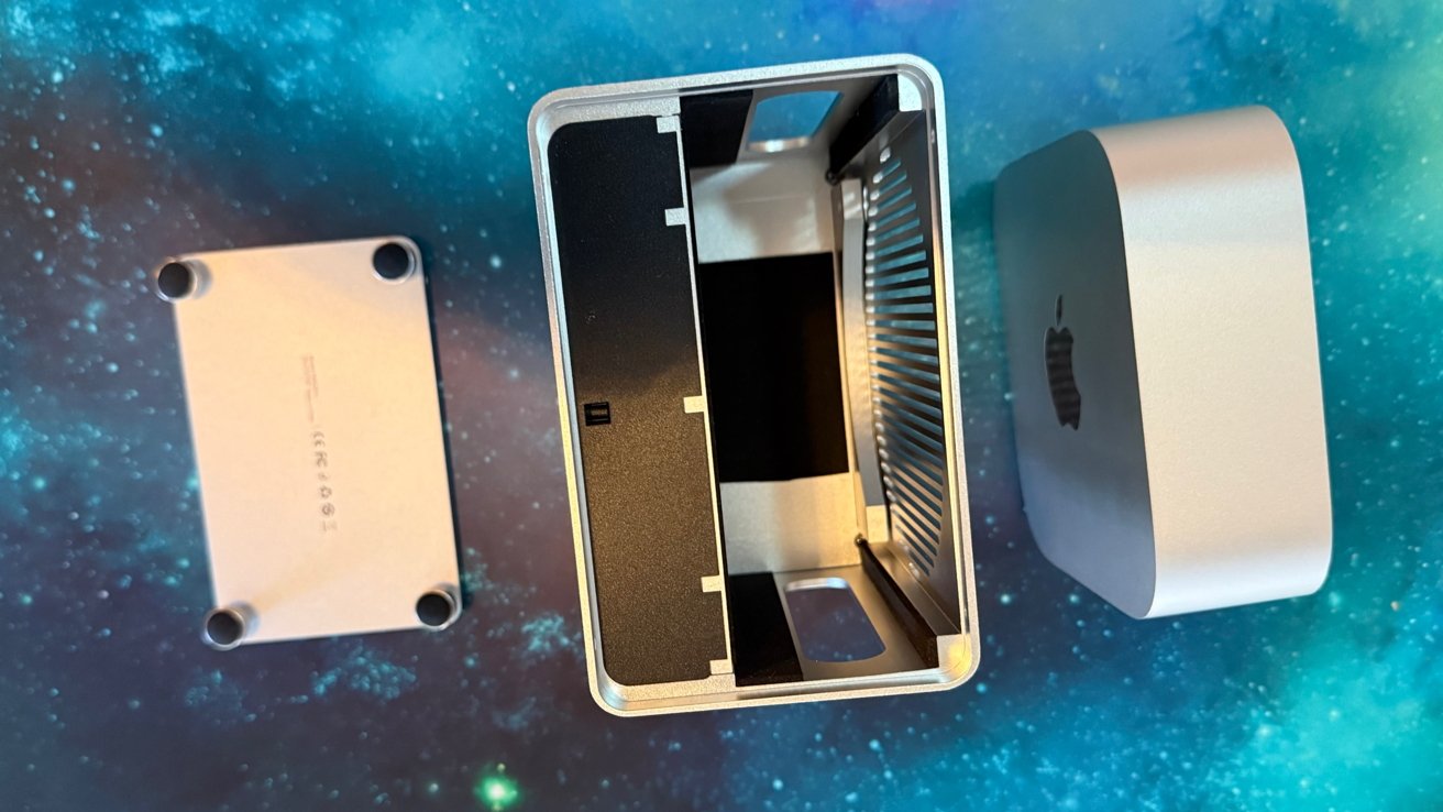 An open silver computer case with a separate base and cover, revealing the internal components, on a starry blue background.