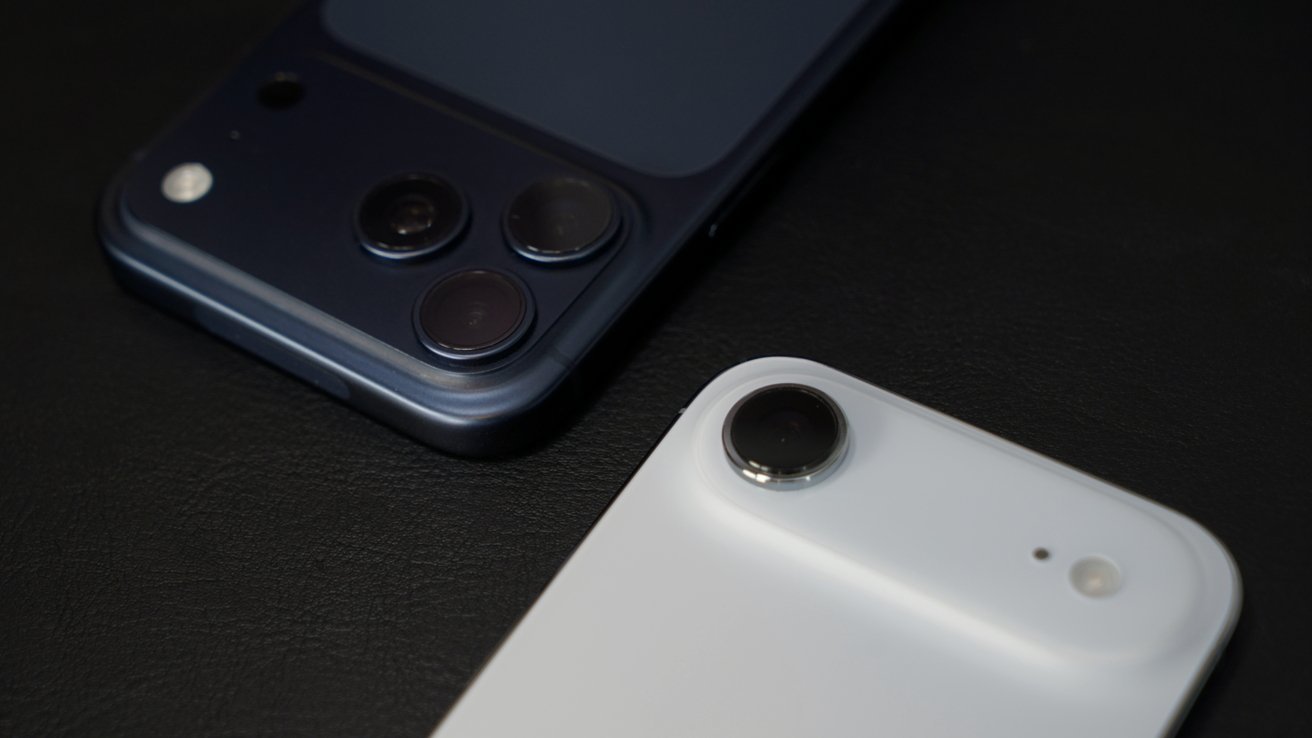 Two smartphones on a dark surface, one with a blue case featuring three camera lenses, the other with a white case and two lenses.