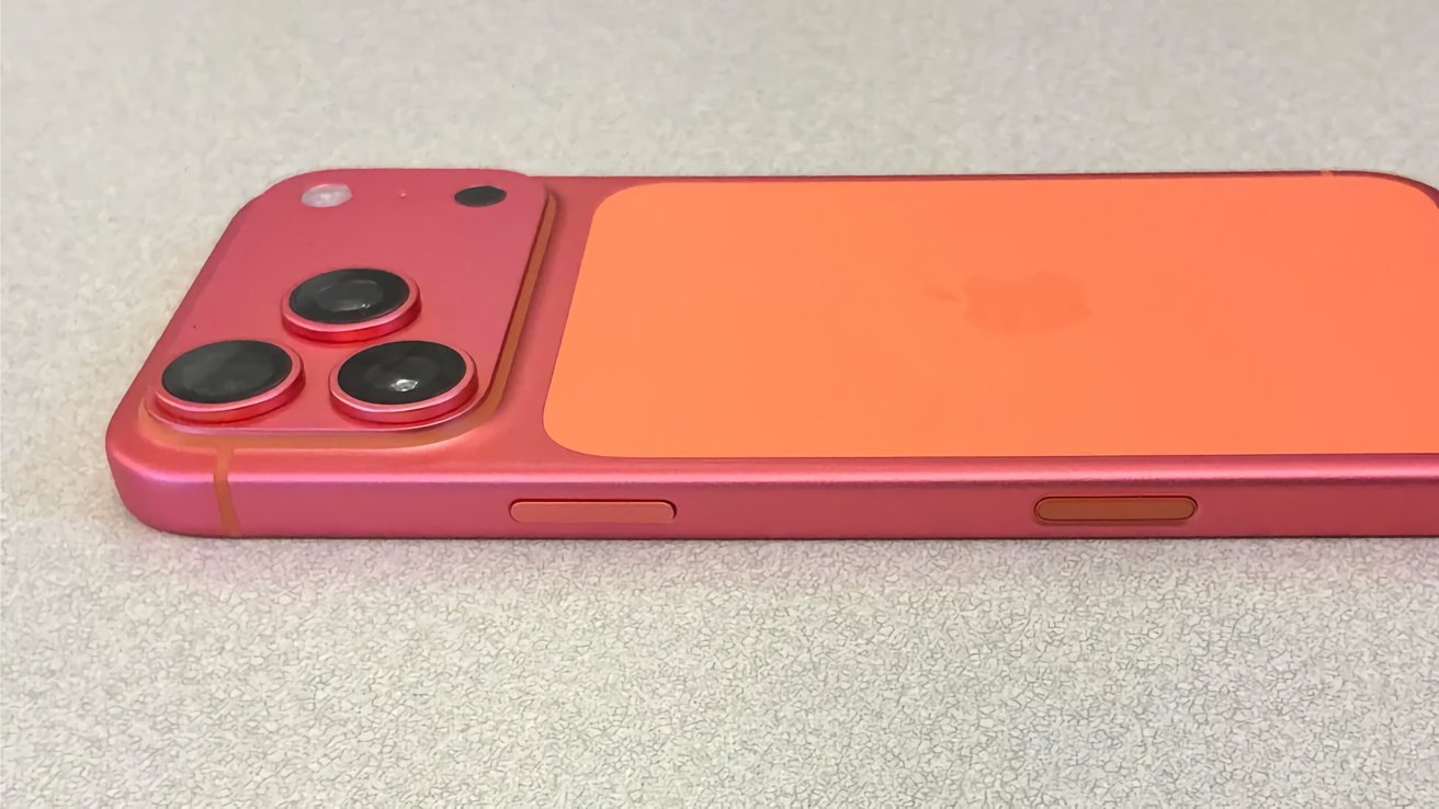Pink and orange smartphone on a gray surface, featuring two prominent camera lenses and a small circular button.