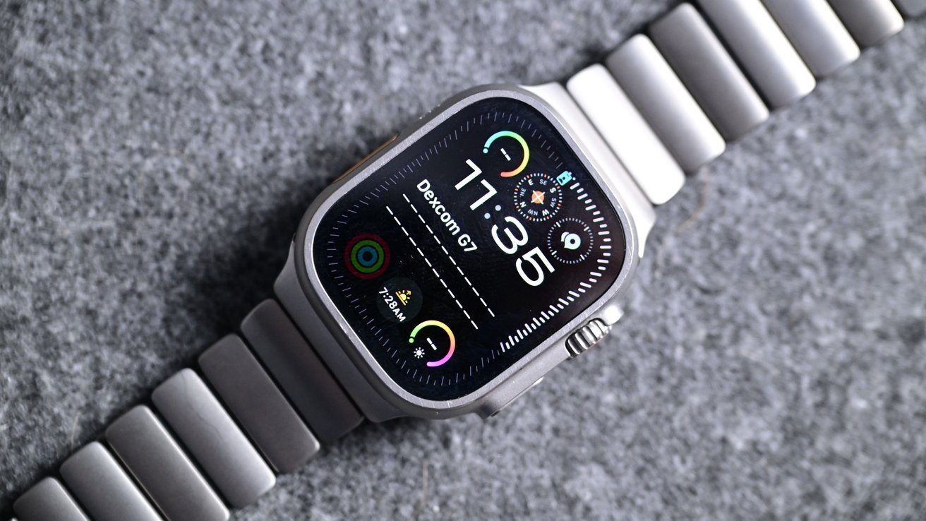 A smart watch with a metal band displays the time 11:35, colorful icons and various health metrics on a dark background on a gray surface.