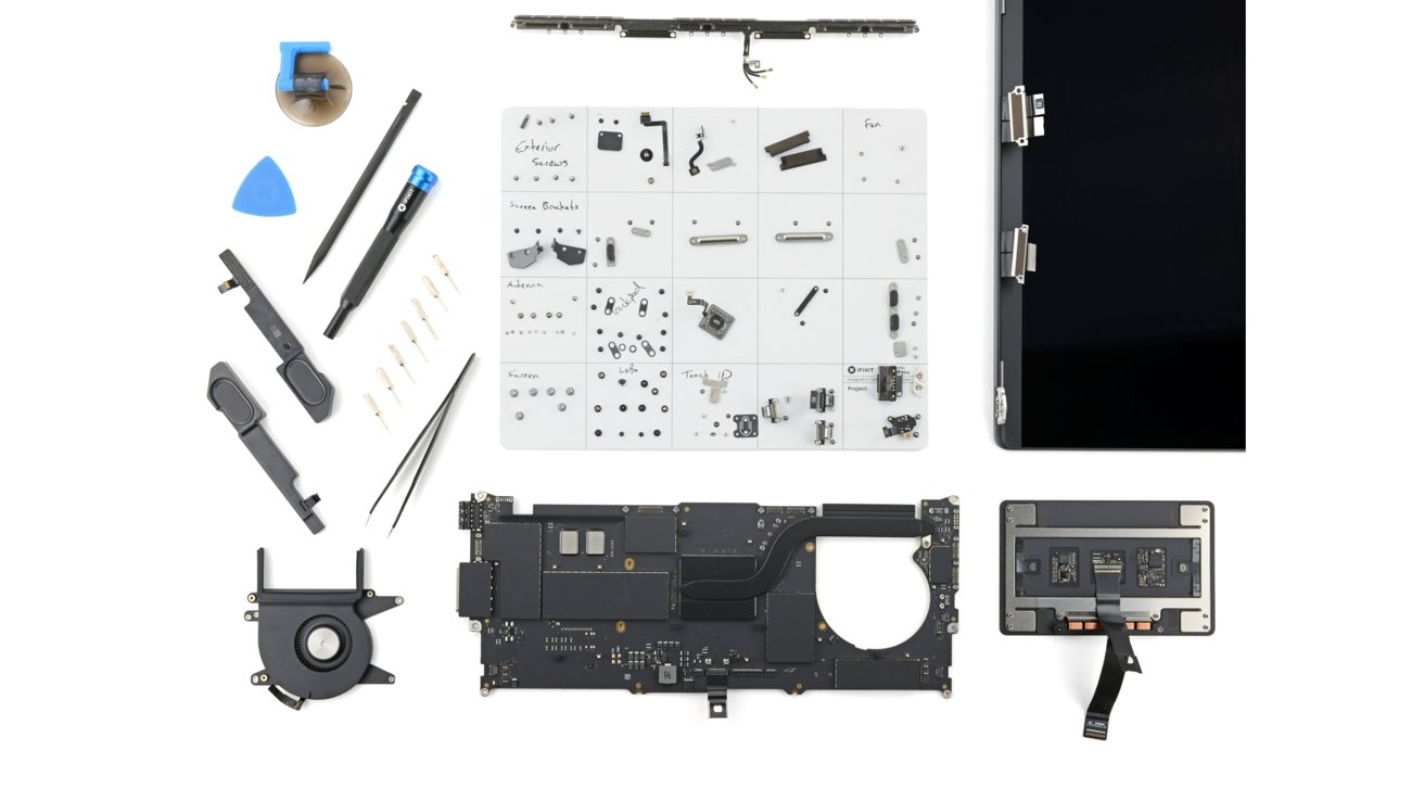 Disassembled electronic device components and tools, including a circuit board, fan, screen, and various small parts organized on a grid, with repair tools like screwdrivers and tweezers.