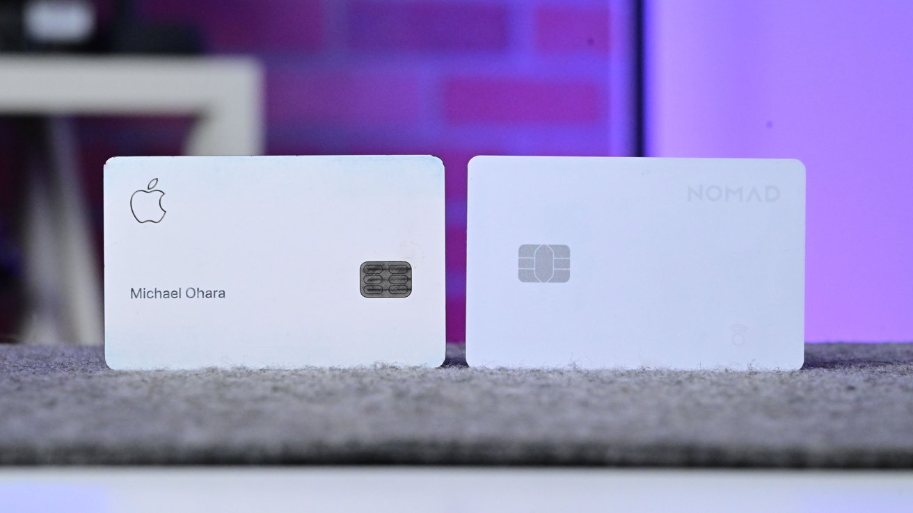 Two white cards with embedded chips displayed on a textured surface. Left card has logo and text; there is a logo on the right tab. The background has a blurred purple wall.