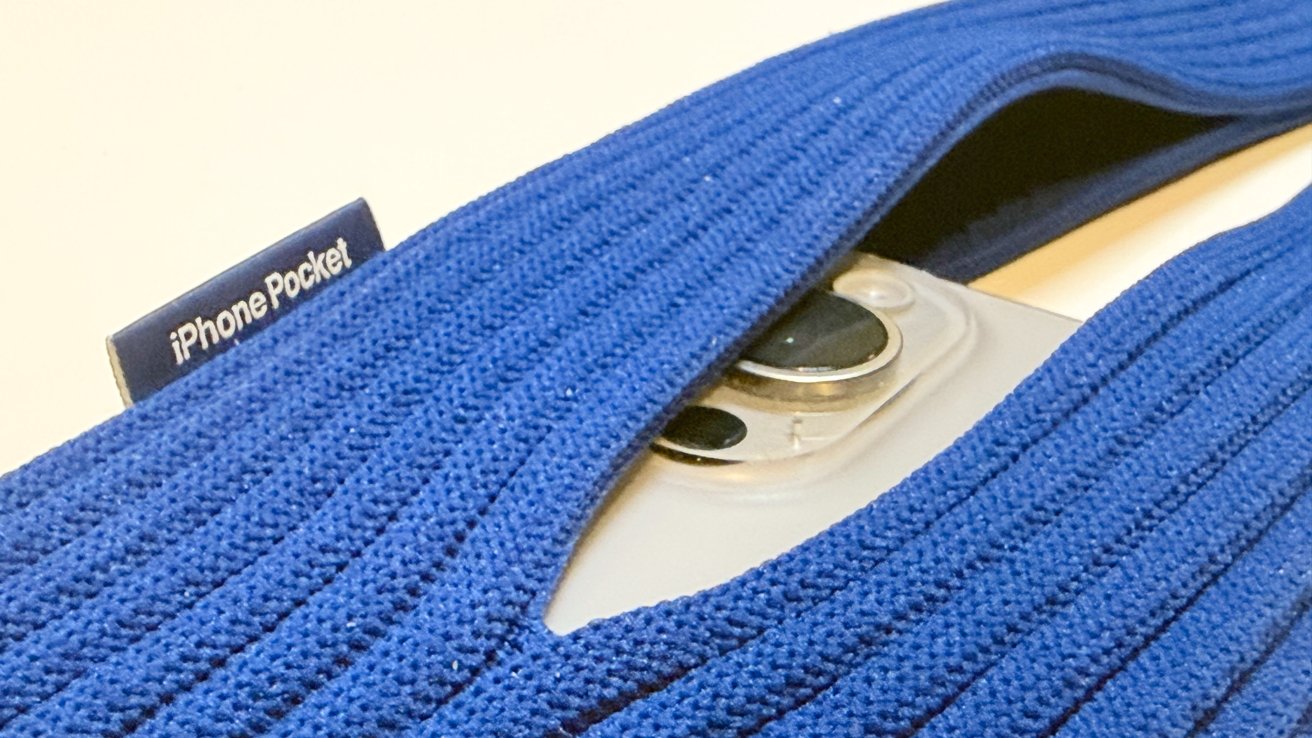 A blue fabric band partially covers a smartphone, revealing the camera. A small label reads 'iPhone Pocket.'