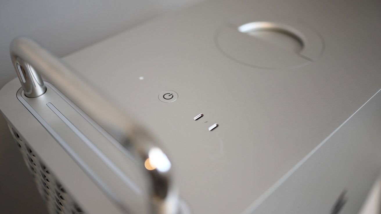 Silver computer tower with a handle, power button, and ventilation holes on the side.