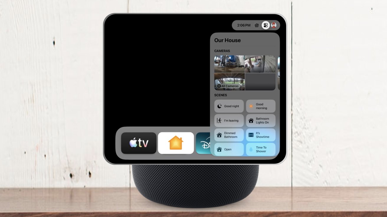 Tablet displaying home automation app with camera feeds and scene options sits on a smart speaker, placed on a wooden surface and background.