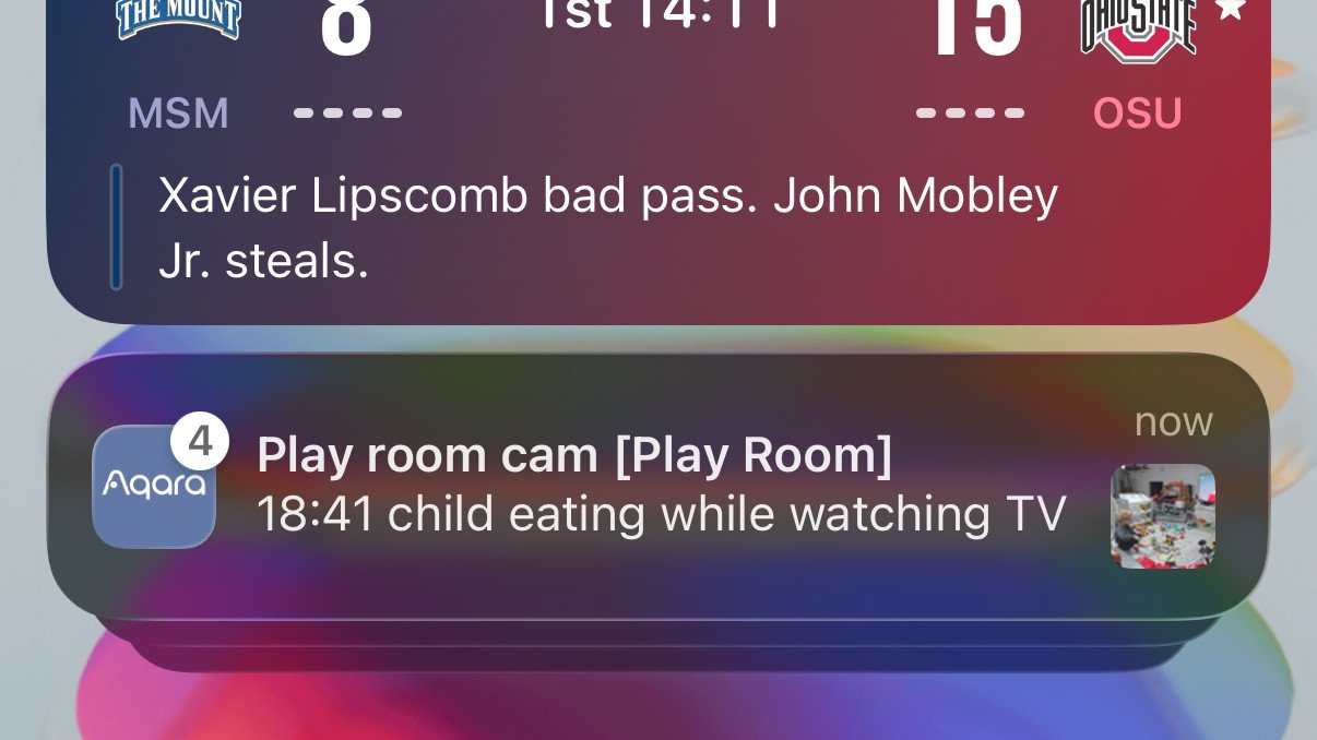 Sports scoreboard showing MSM 8, OSU 15, with a play update. Notification below shows a child eating while watching TV from a playroom camera.