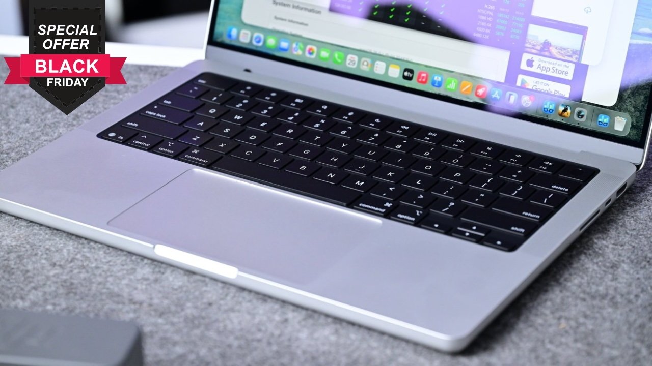 Open MacBook Pro laptop on a gray surface with a Black Friday special offer badge.