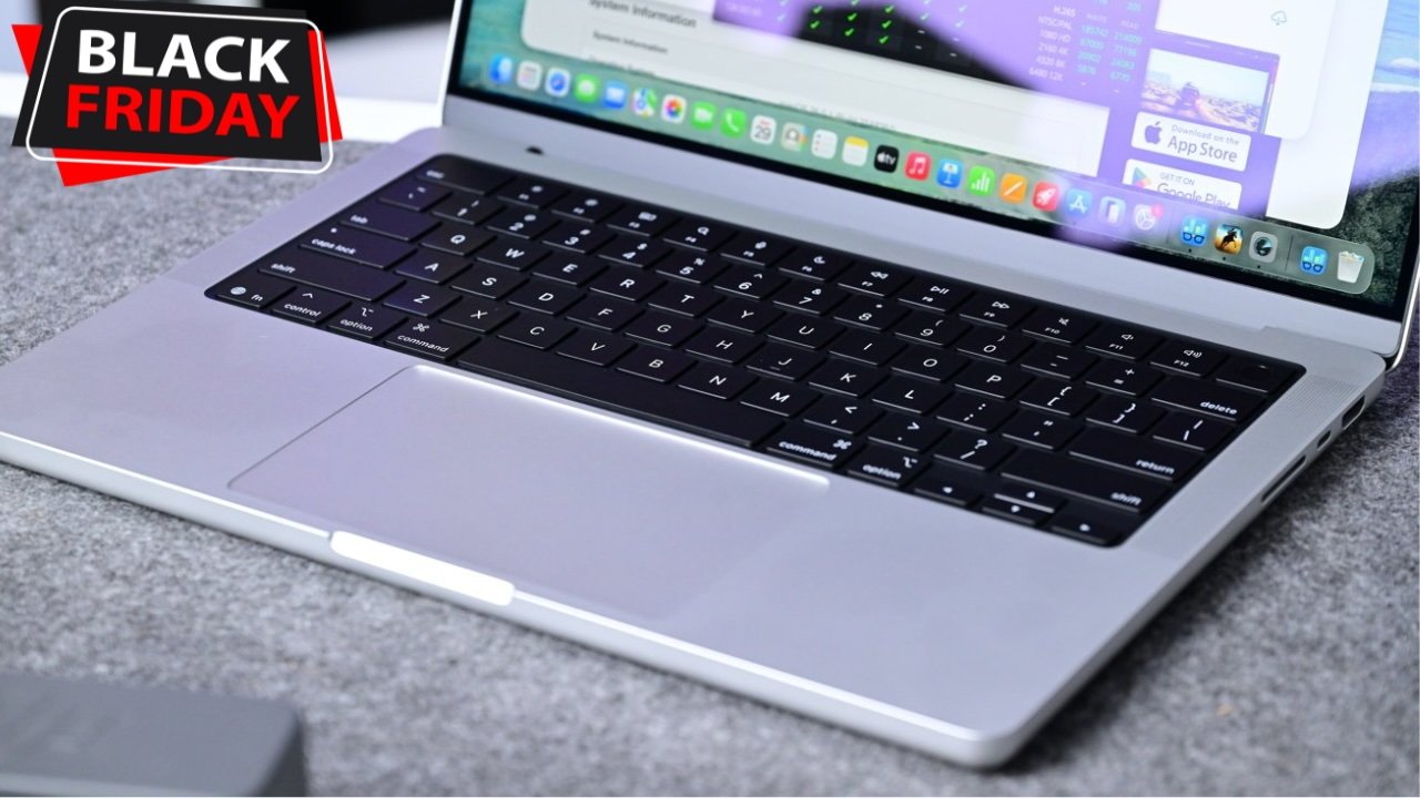 Open M5 MacBook Pro laptop on a gray surface, displaying Black Friday sale banner in the corner, with various app icons visible on the screen.
