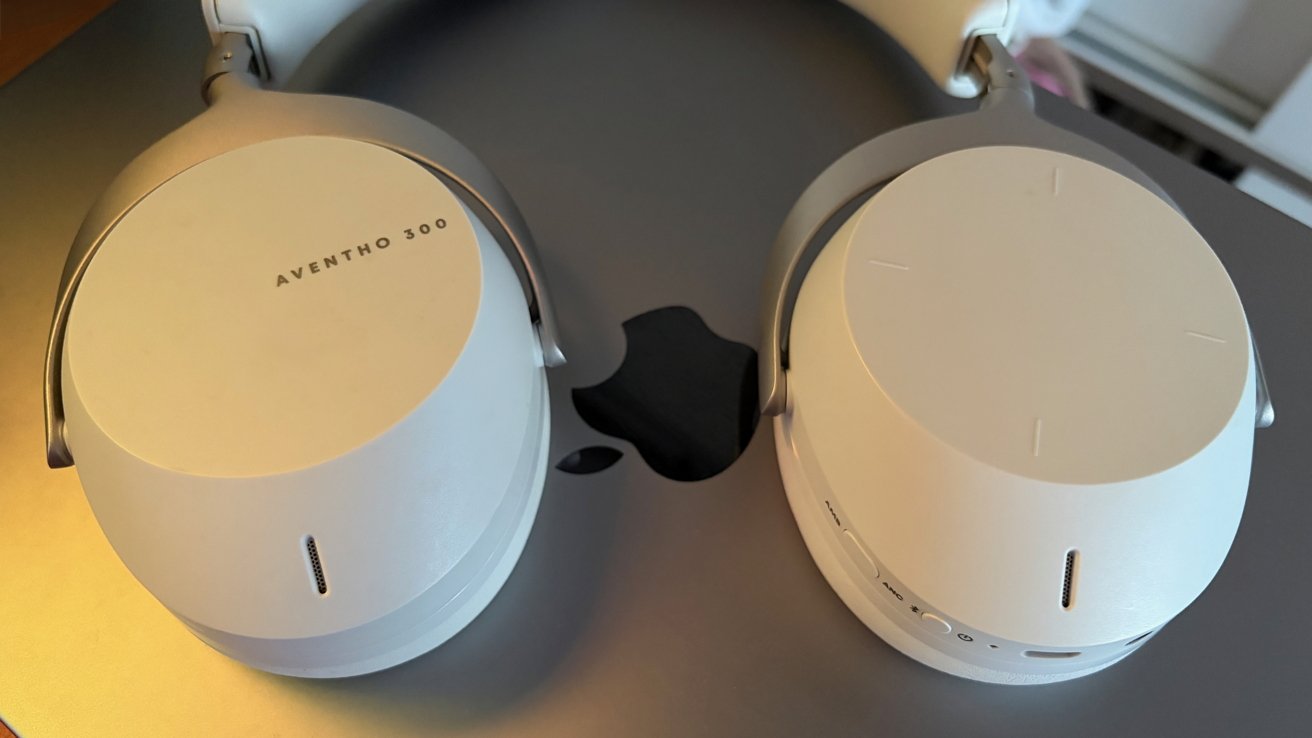 White over-ear headphones with 'AVENTHO 300' text rest on a gray surface featuring a bitten apple logo.