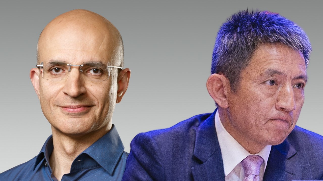 Two men are shown. The left man is bald with glasses and a blue shirt, smiling slightly. The right man has short hair, wearing a blue suit and tie, looking serious.