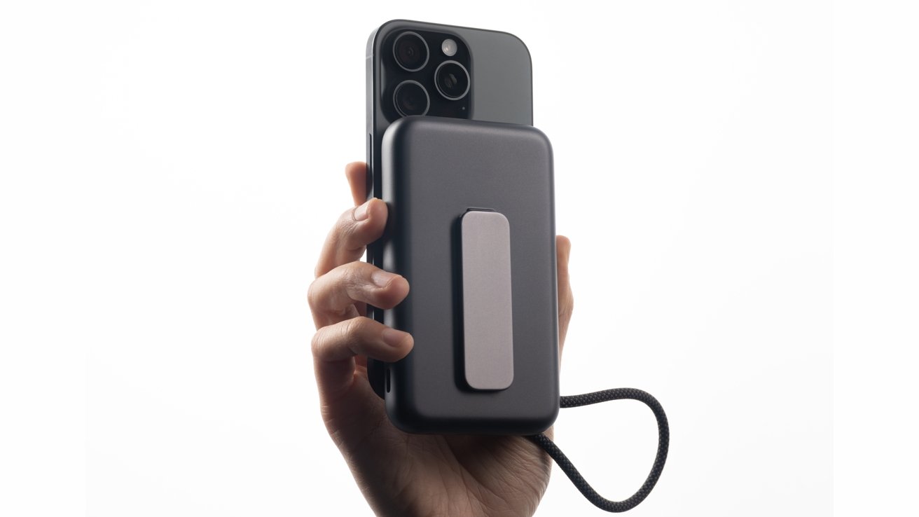 A hand holding a smartphone attached to a dark rectangular device with a strap, against a plain white background.