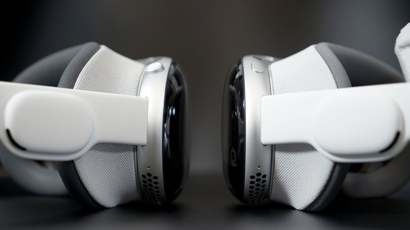 Close-up of two Apple Vision Pro models facing each other on a dark background.