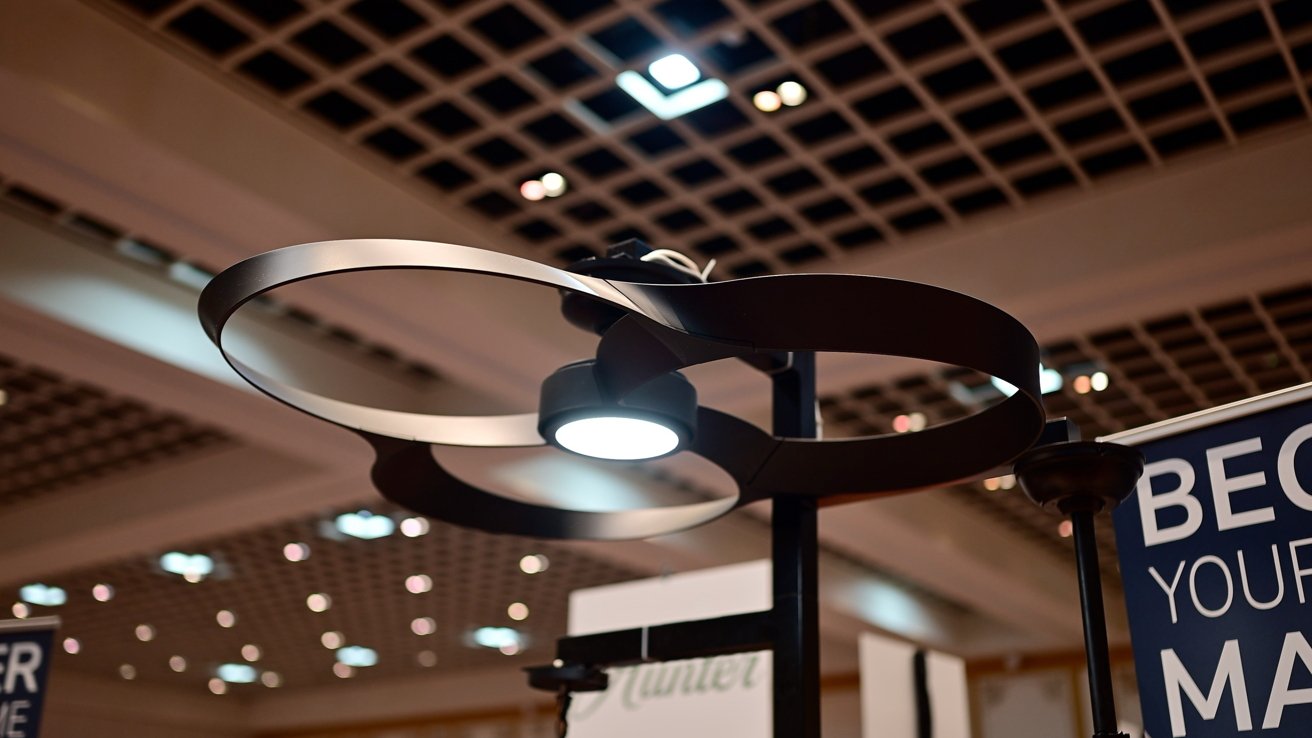 Modern ceiling chandelier with two circular metal rings and a central light, set against a grid-patterned ceiling.