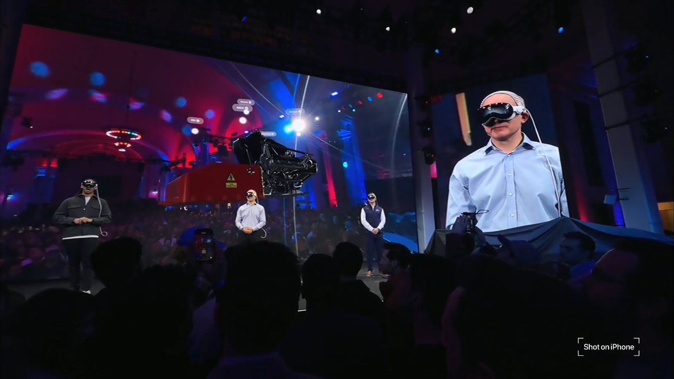 People on stage present wearing Apple Vision Pro, a label in the corner of the image says 'shot on iPhone'