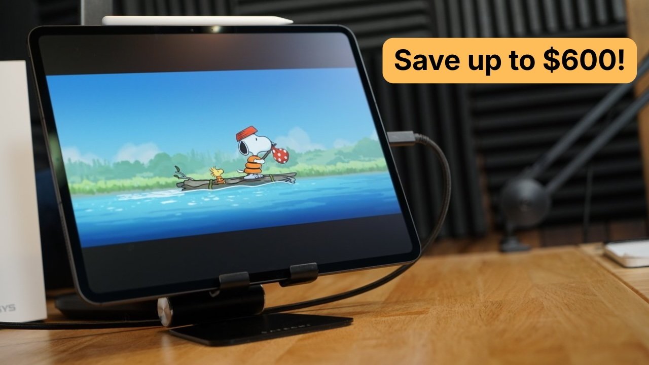 iPad Pro tablet on a stand playing a Snoopy cartoon, showing Snoopy and Woodstock rafting on blue water, with a banner reading Save up to $600 in the upper right corner