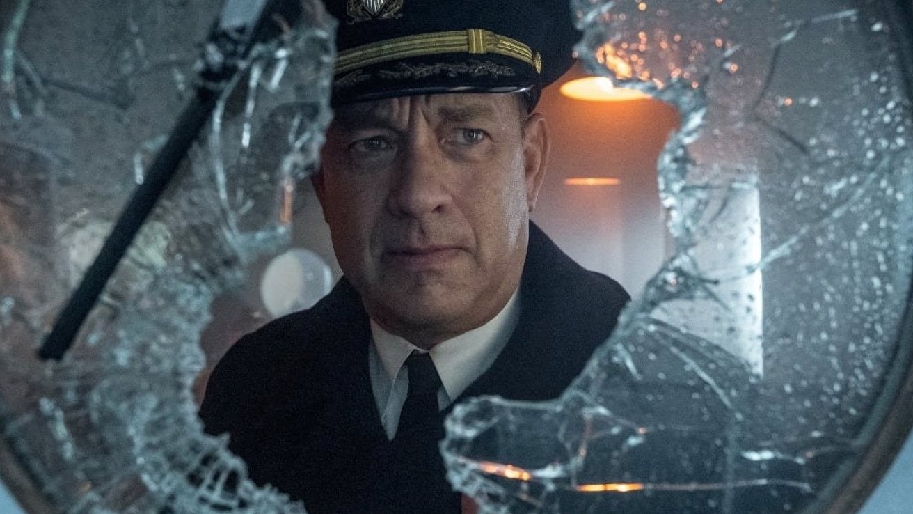 Worried naval officer in dress uniform and cap seen through a large shattered circular window, surrounded by jagged glass fragments and dim, cool-toned interior lighting