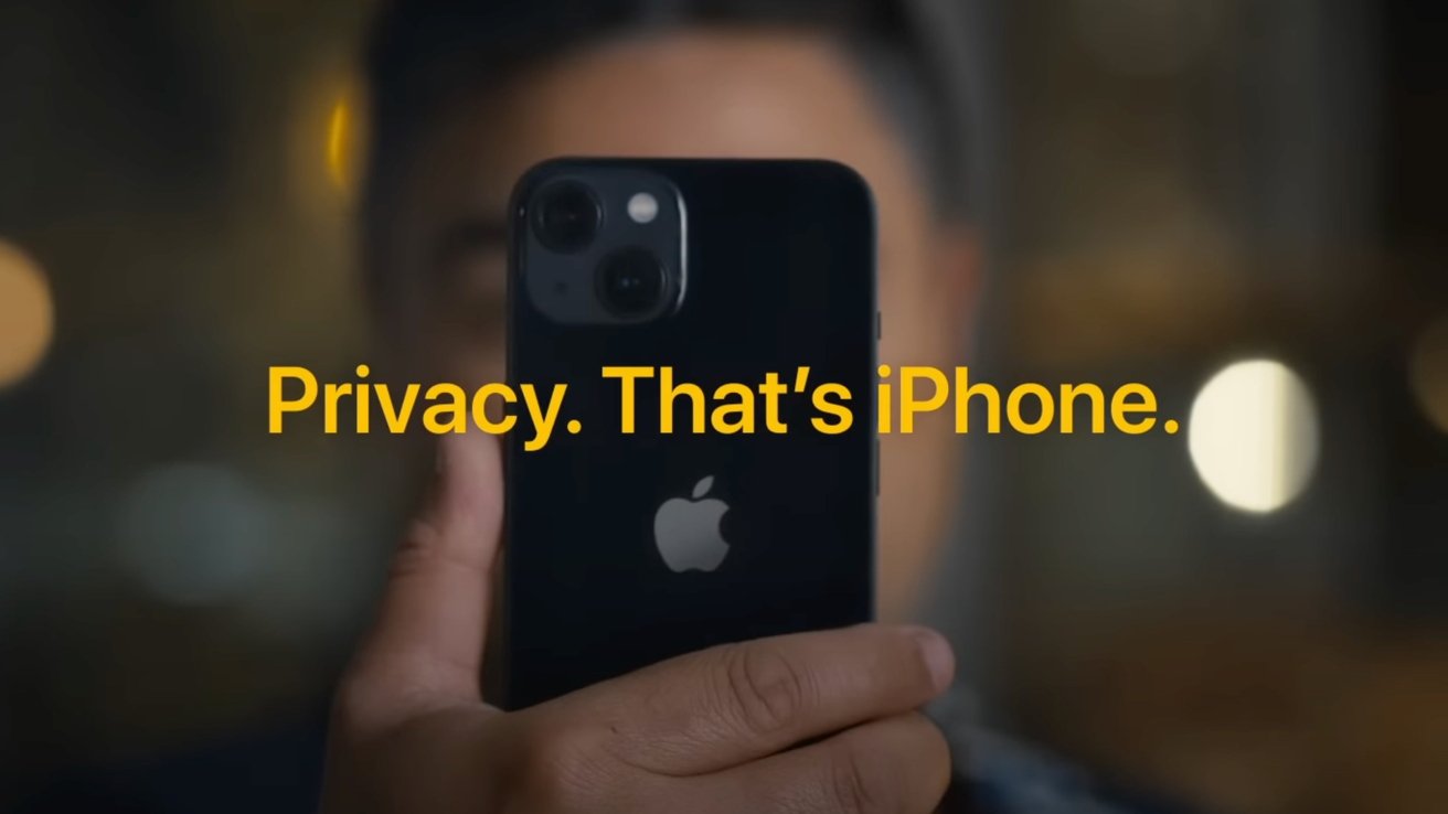 A person holding a black iPhone to their face at night with blurred city lights in the background and bold yellow text that says Privacy. That's the iPhone through the middle