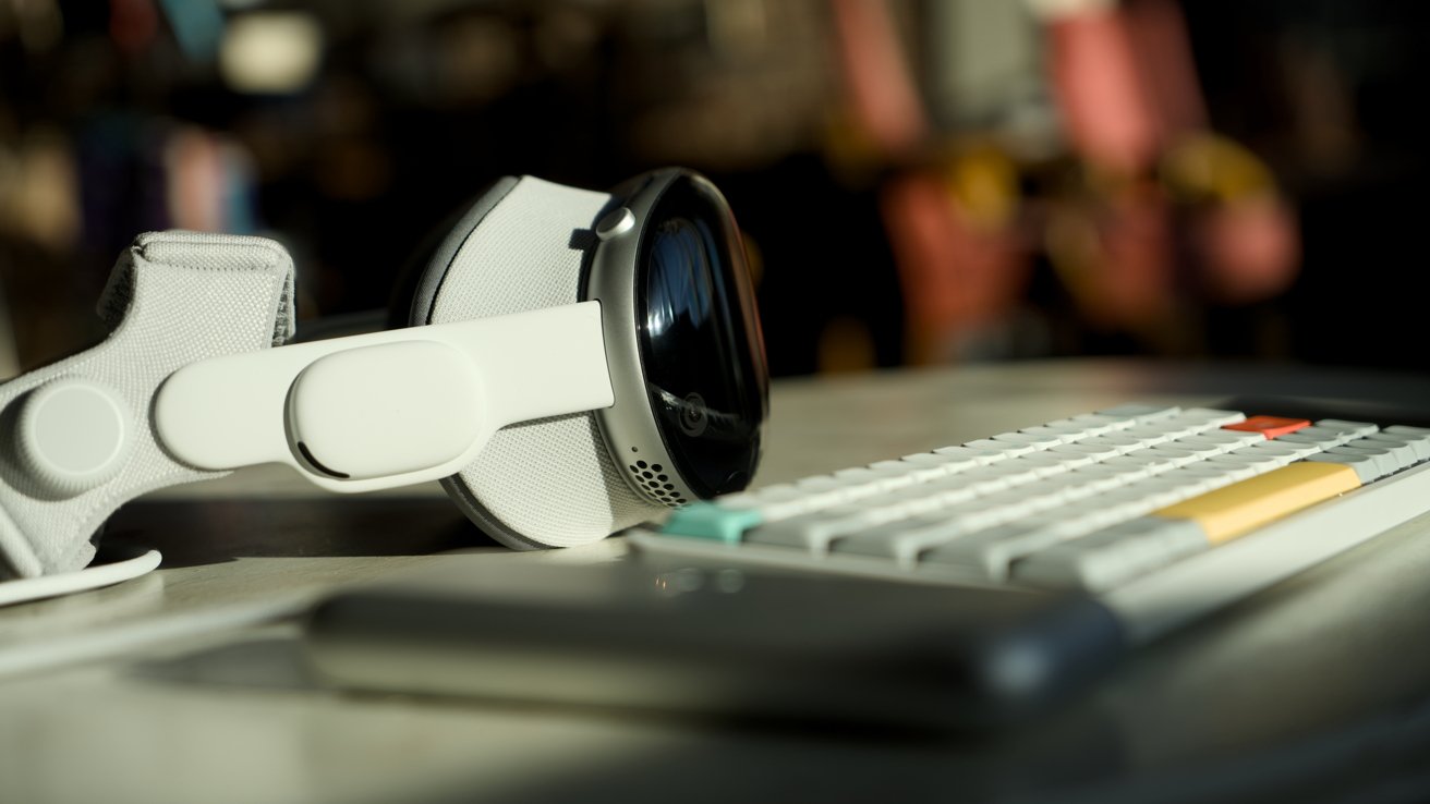 Apple Vision Pro on a table by a portable mechanical keyboard