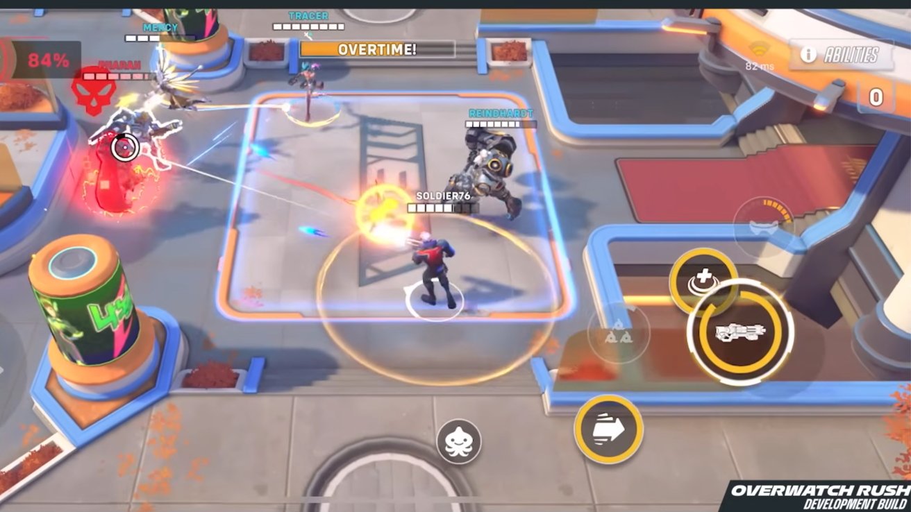 Topdown view of colorful Overwatch mobile match showing Soldier 76, Reinhardt, Mercy and Tracer fighting on a control point in overtime, with health bars, ability buttons and UI overlays visible