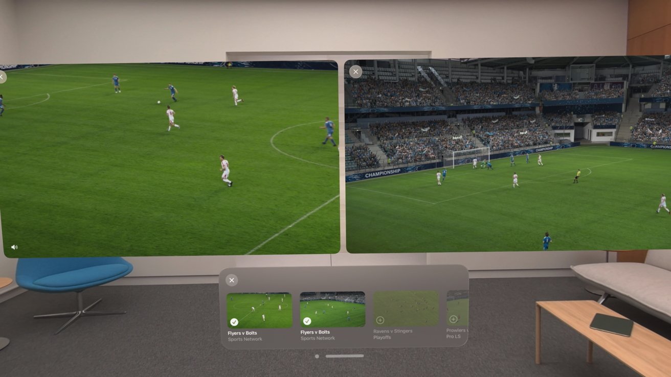 Virtual living room with two large floating soccer broadcasts, one wide field view and one near the goal, above a control bar of game thumbnails, chair, couch, and coffee table