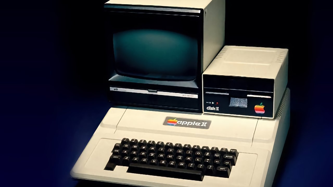 Vintage beige Apple II computer with built-in keyboard, paired with a small CRT monitor and external disk drive, all featuring classic rainbow Apple logos against a dark background