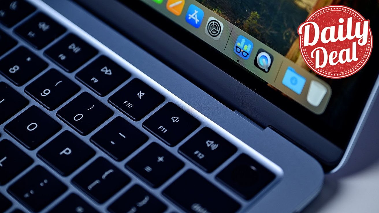 Close-up of a MacBook laptop keyboard and macOS dock on screen, with a red circular Daily Deal badge in the upper-right corner indicating a special offer or promotion