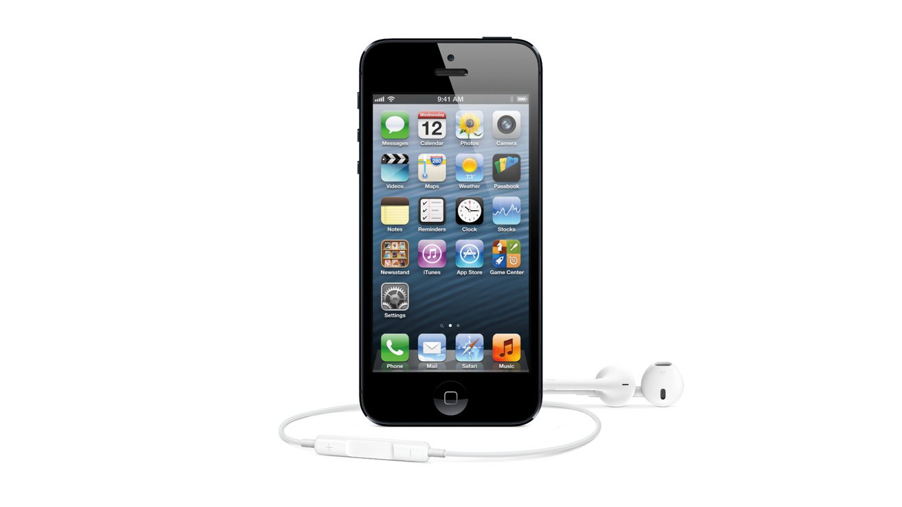 Black iPhone with home screen icons displayed, standing upright on a white background, with white wired EarPods lying in front, cable loosely coiled and inline remote visible