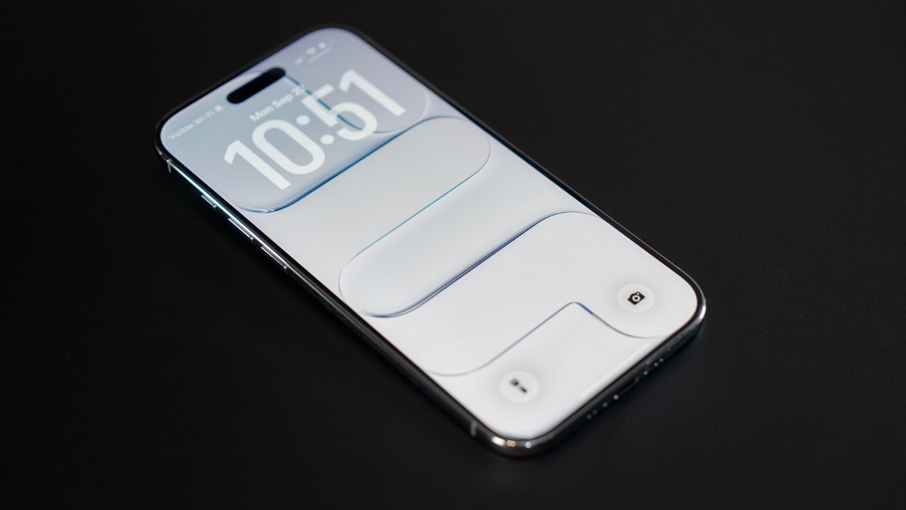 Modern smartphone lying on a dark surface, screen on, showing a minimal white lock screen with large digital clock numbers and subtle rounded rectangular design elements