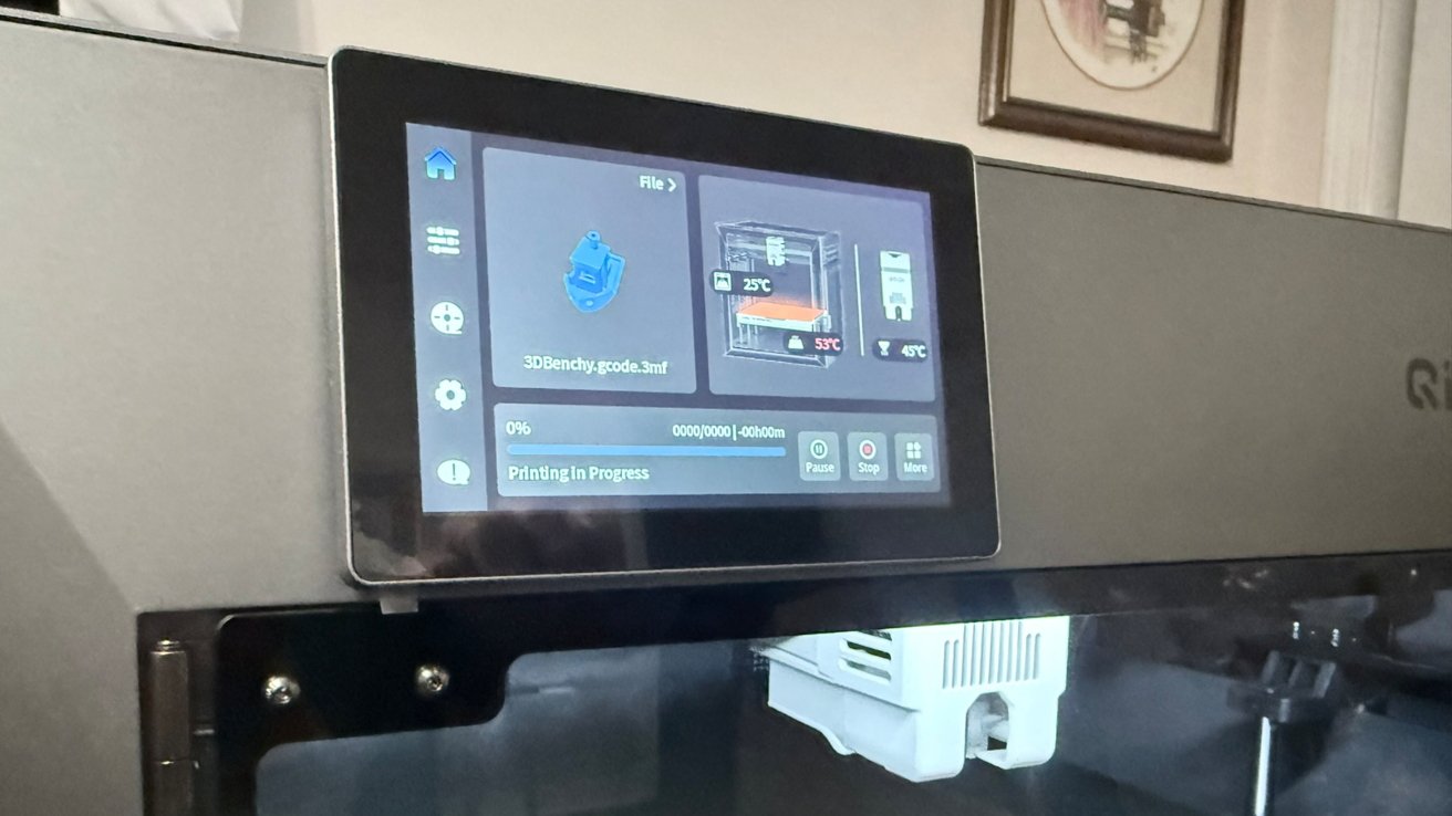 Close view of a 3D printer control panel showing a touchscreen interface with a 3DBenchy print job status, temperature readouts, and buttons for pause, stop, and more options