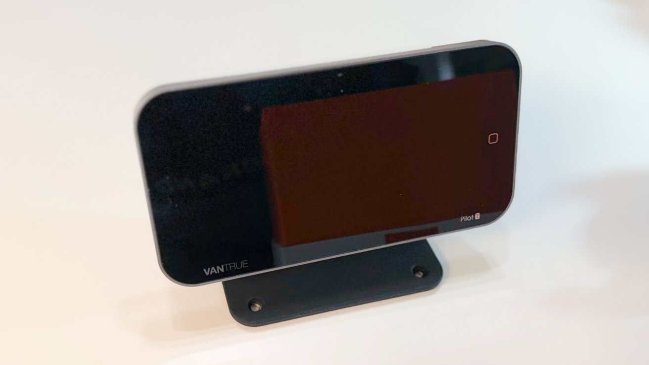 Black rectangular Vantrue Pilot dash cam with a dark reflective screen, rounded corners, and a small square touch button, mounted on a flat black base against a plain background