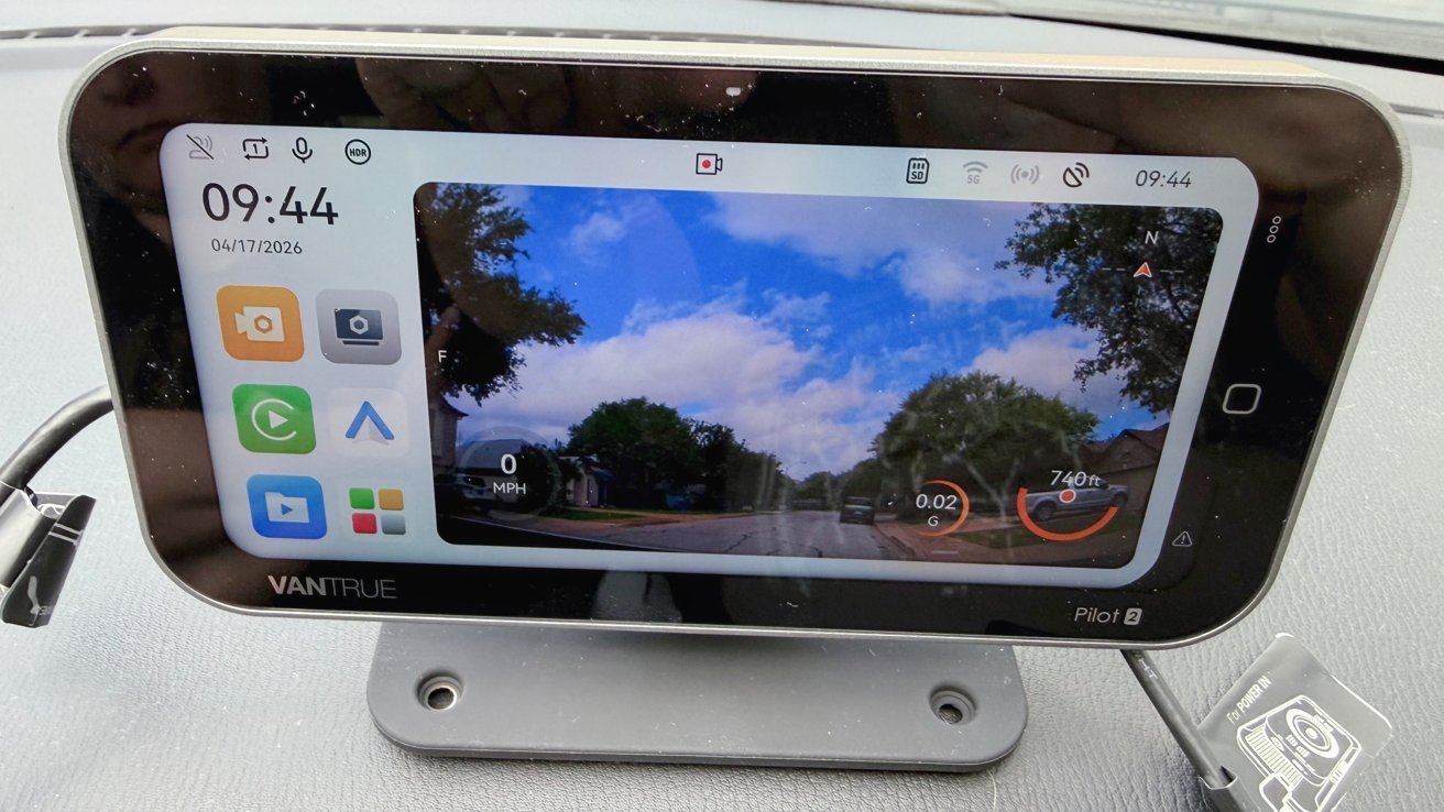 Car dashboard-mounted Vantrue Pilot 2 screen showing dashcam road view with trees and cloudy sky, speed and distance gauges, time 09:44, date 04/17/2026, and colorful app icons on the left