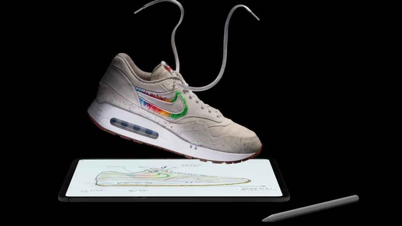 Sneaker with colorful Nike swoosh floats above digital tablet showing its sketch, with loose laces hanging upward and a stylus resting beside on a black background
