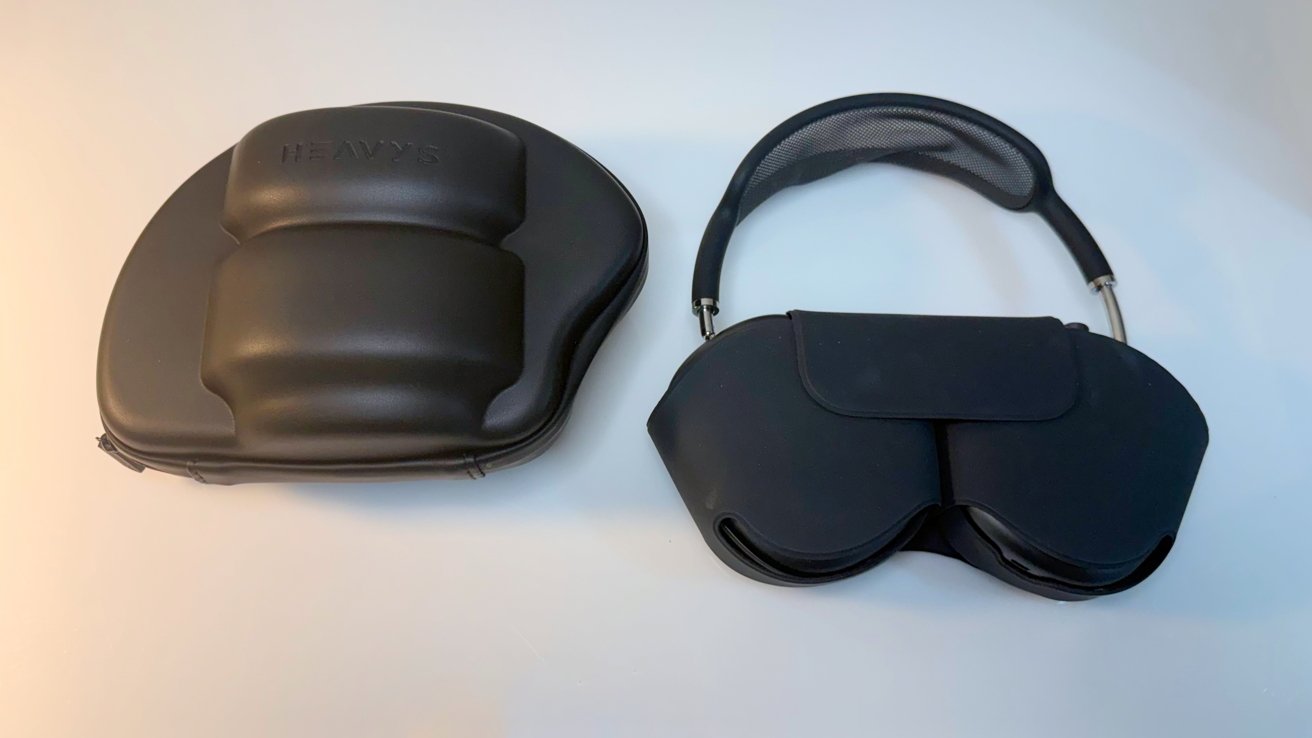 Two black headphone cases on a light surface: a rounded hard case labeled HEAVYS on the left, and a foldable soft case with a curved carrying handle on the right