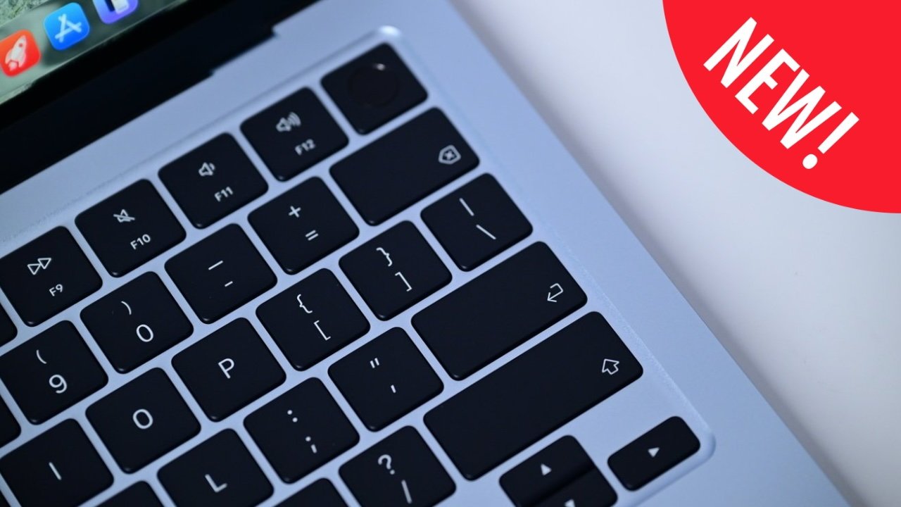 Close-up of an M5 MacBook Air laptop keyboard with black keys and silver casing, showing function and bracket keys, plus a red corner badge reading NEW on a white background